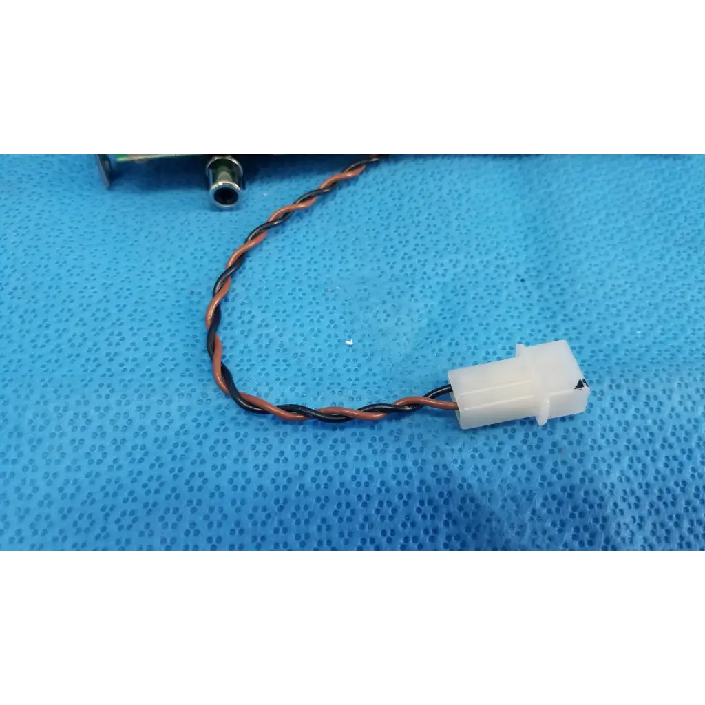 A white plastic connector attached to a twisted orange and black wire on the back of a teli q3b15569fsa lcd monitor control driver board panel
