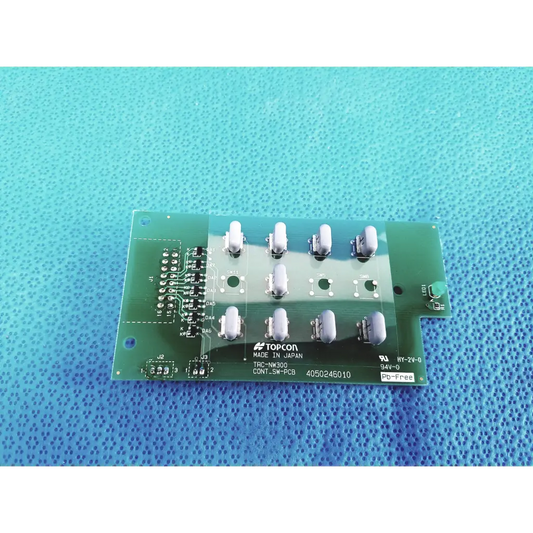 Green topcon trc-nm300 control switch pcb board with white cylindrical components and printed labeling for control switch