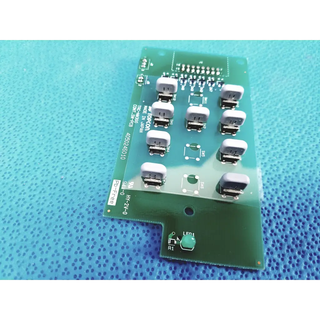 Green printed circuit board with gray rectangular components and white labeling of topcon trc-nw300 control switch pcb board