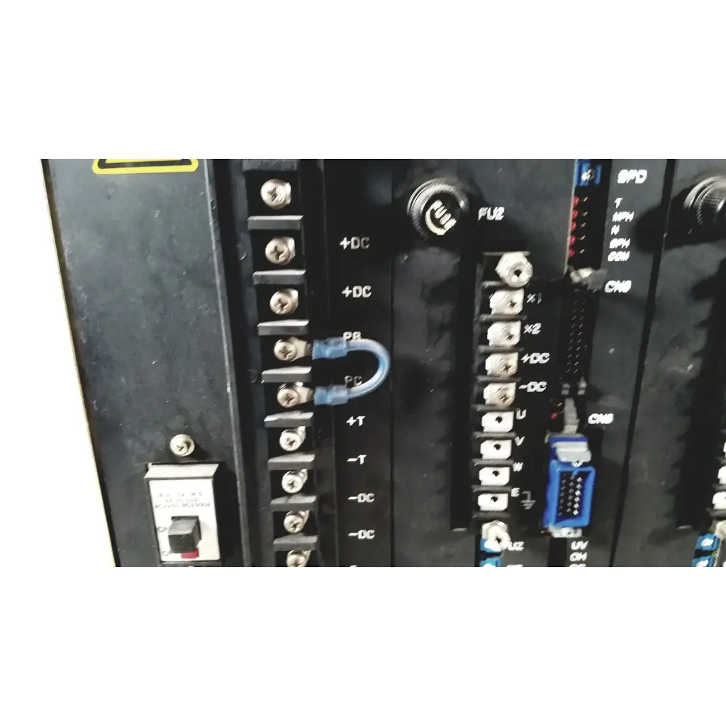 Blue plastic u-shaped terminal connector attached to black industrial control panel on toshiba ra power rad92-1008 power supply