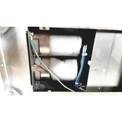 Two white cylindrical capacitors with metallic ends secured by wires inside metal enclosure of toshiba ra power rad92-1008 power supply
