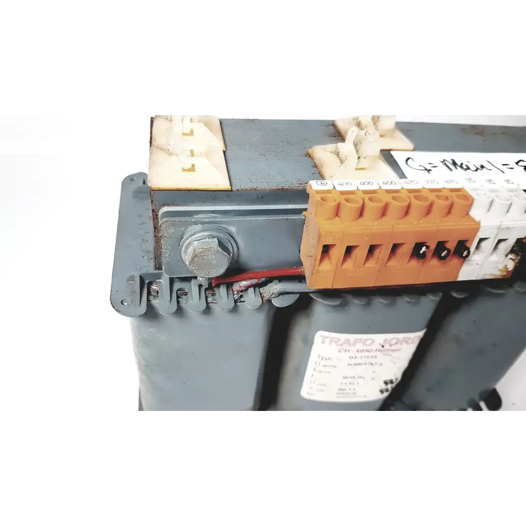 Orange and white electrical terminal block mounted on gray industrial trafo jordi ch-4950 huttwil transformer