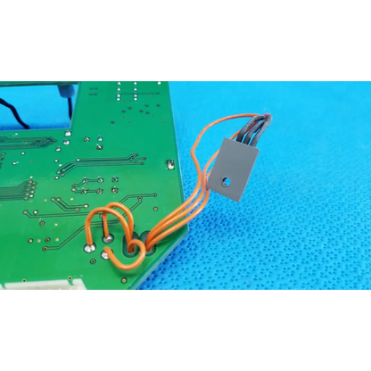 Gray rectangular heat sink with orange insulated wires connected to a green video interface circuit board for topcon retinal camera