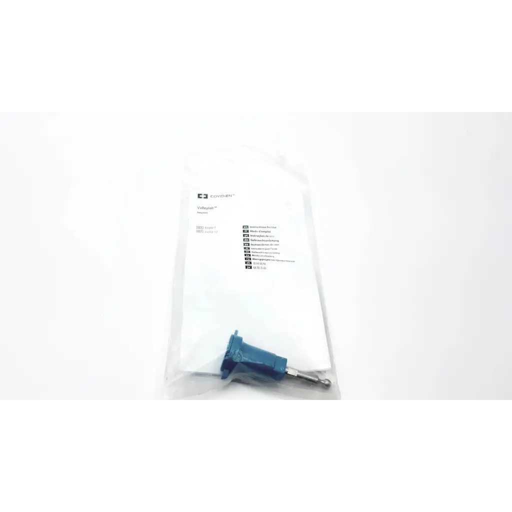 Blue plastic Valleylab E0502 universal monopolar adapter with metallic pin in clear vollmer packaging bag