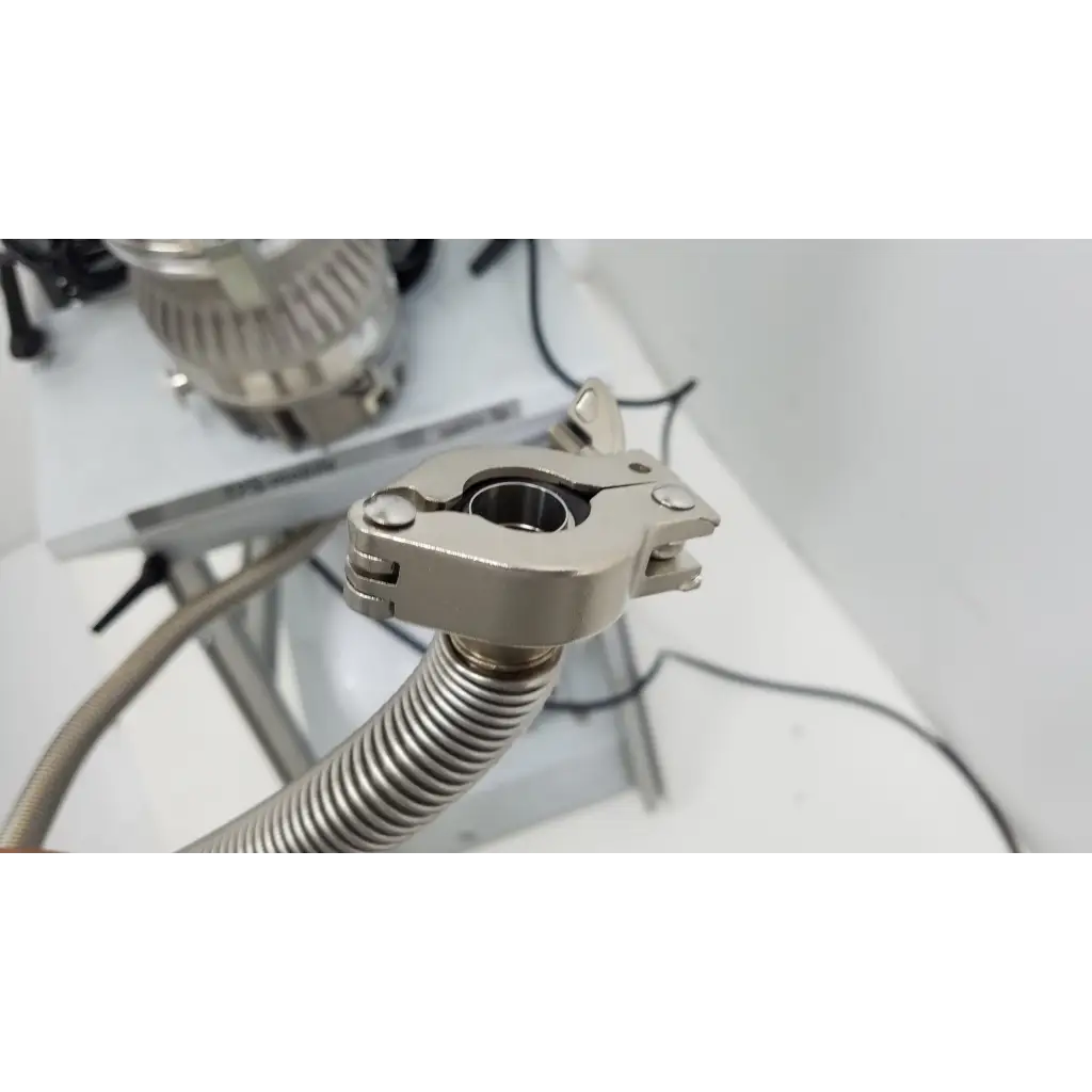 Silver metallic clamp securing flexible corrugated hose on back side of turbo-v 301-ag navigator vacuum pump system