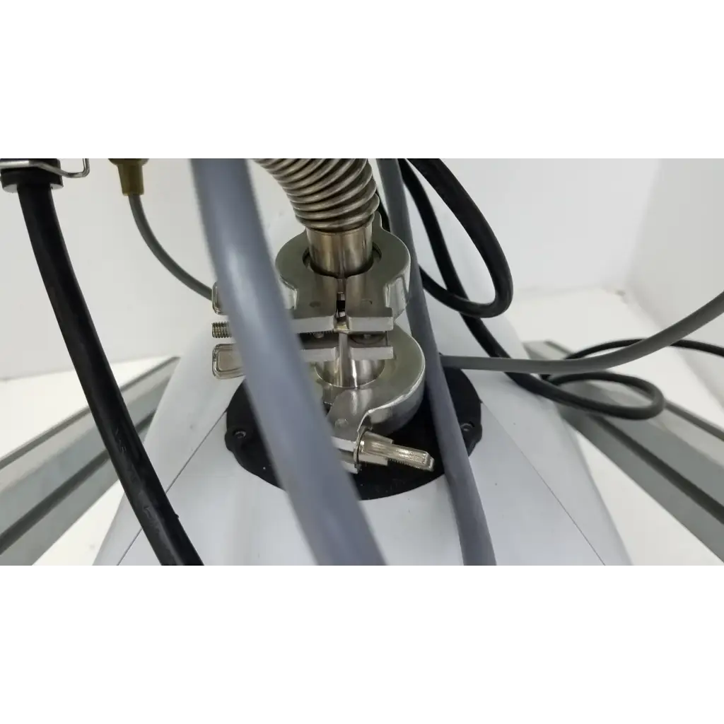 Silver metallic clamp with coiled spring securing gray tubing on the turbo-v 301-ag navigator vacuum pump system
