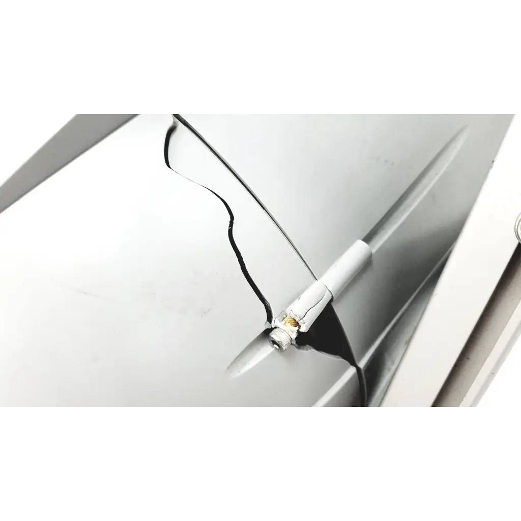 A white cylindrical tire pressure gauge with metallic tip attached to a silver car door for turbo-v 301-ag navigator use