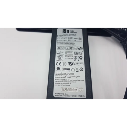 Black plastic elo ac adapter with white label showing specifications for vecna medical system medical kiosk