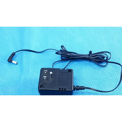Black plastic welch allyn transformer adapter power supply with coiled cable and right-angle connector for 120v use
