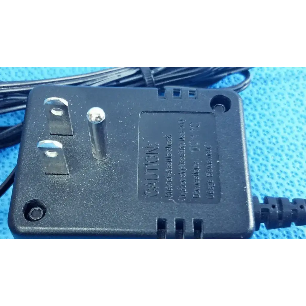Black plastic welch allyn transformer adapter power supply with silver prongs and coiled black power cord for 120v use