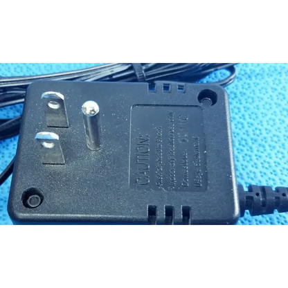 Black plastic welch allyn transformer adapter power supply with silver prongs and coiled black power cord for 120v use