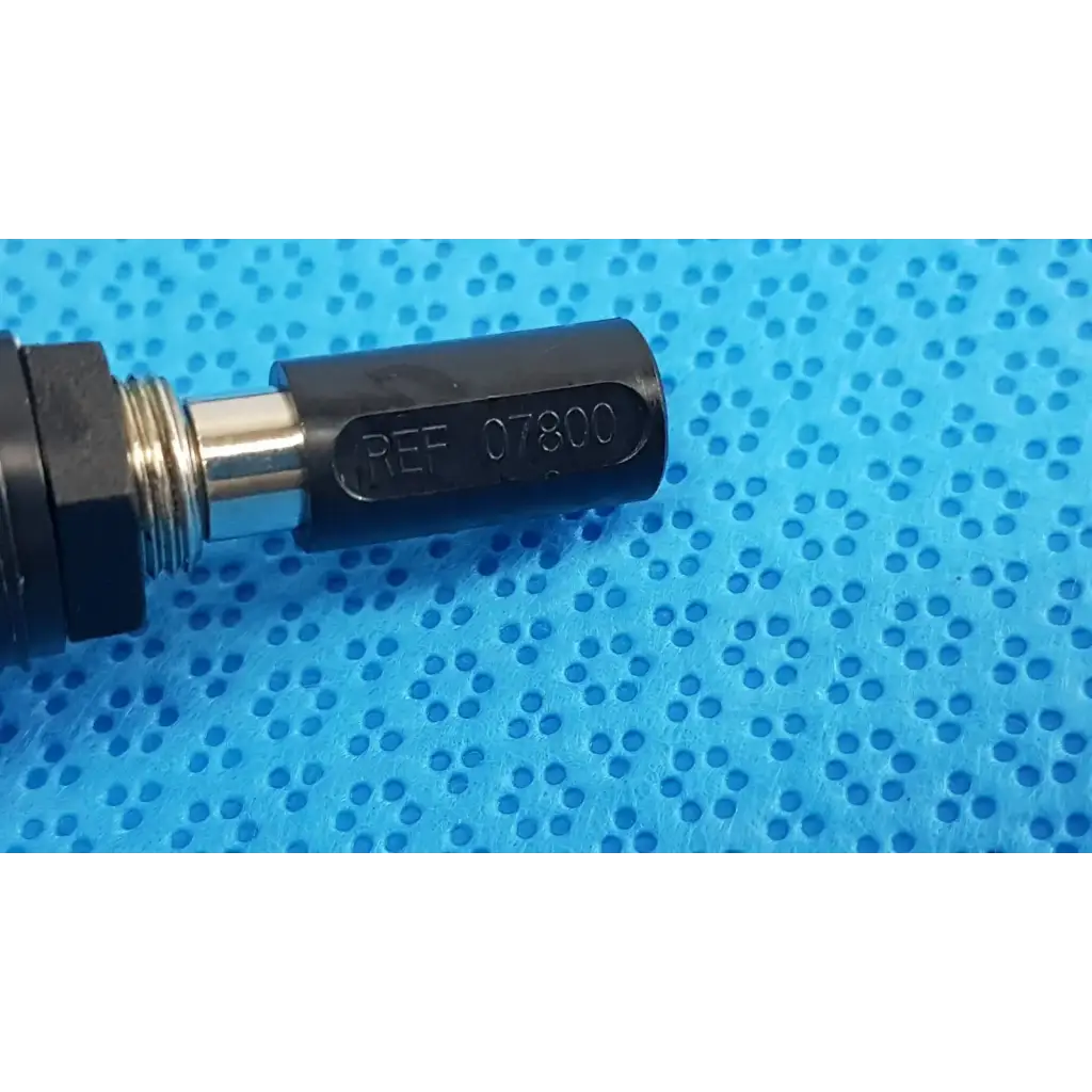 Black cylindrical welch allyn power adapter plug with engraved ref 07800 and metallic threaded section for medical use