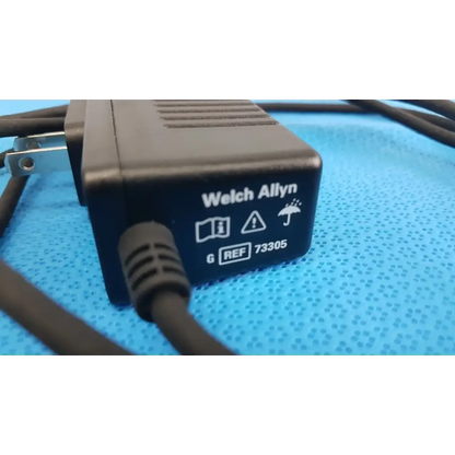 Welch allyn 73305 6v power adapter plug with textured plastic casing and coiled black cord for medical devices