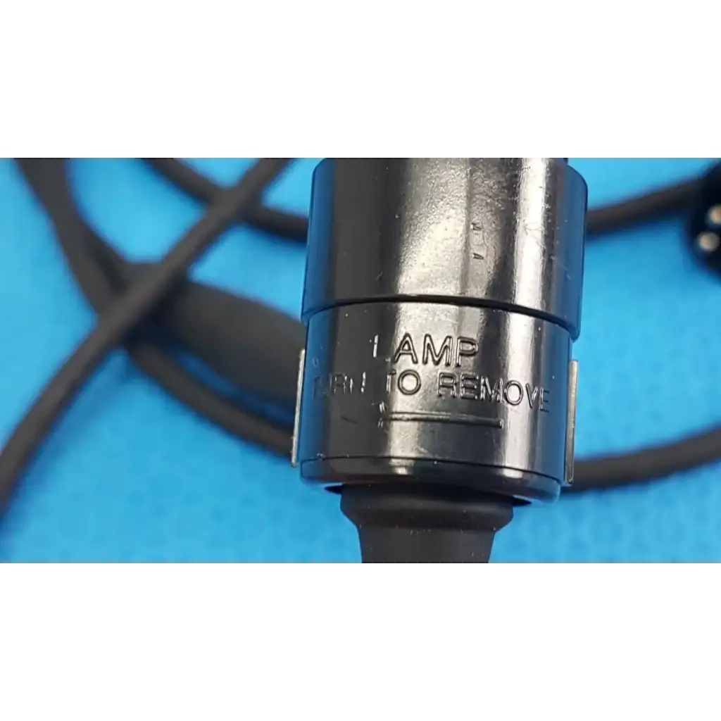 Black metal lamp socket with engraved text and rubberized grip on the back side of welch allyn power adapter plug