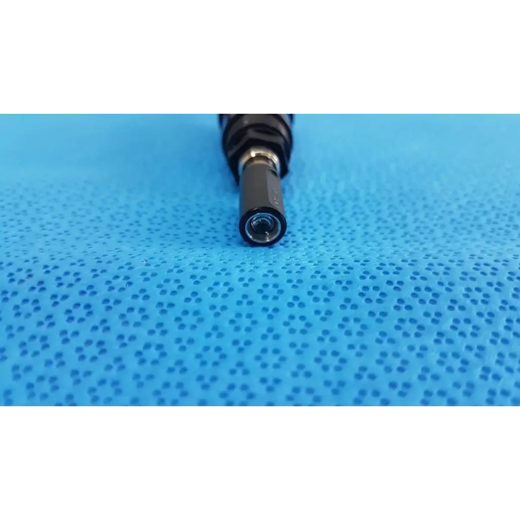 Black cylindrical end of medical endoscope lens shown on the back side of welch allyn 73305 6V power adapter plug