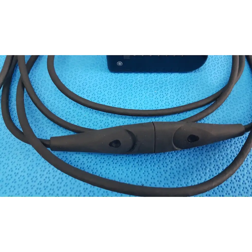 Black silicone-coated welch allyn power adapter plug with central control module and two circular buttons for medical devices