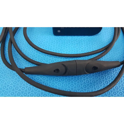 Black silicone-coated welch allyn power adapter plug with central control module and two circular buttons for medical devices