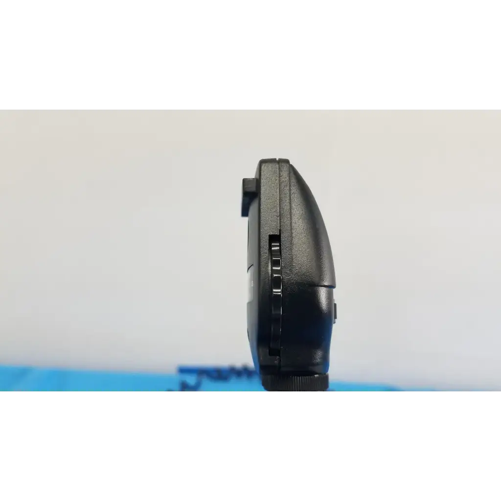 Black plastic handheld gaming device with textured grip and buttons shown with welch allyn 767 series wall transformer