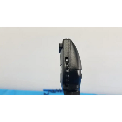 Black plastic handheld gaming device with textured grip and buttons shown with welch allyn 767 series wall transformer