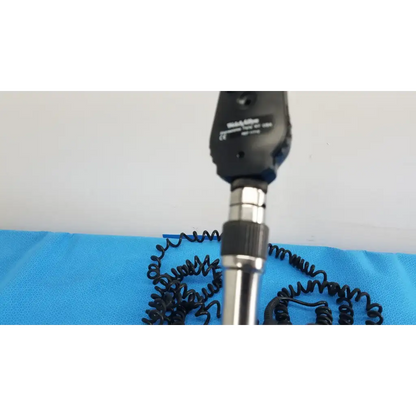 Black and silver handheld ophthalmoscope with coiled black cable from welch allyn 767 series wall transformer product