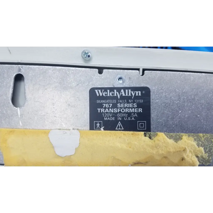 Welch allyn 767 series wall transformer with black label, silver metallic casing, and yellow protective tape at bottom
