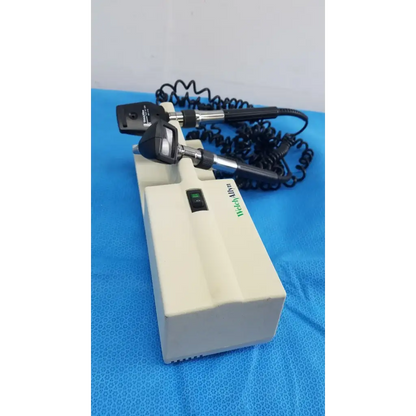 Medical-grade black and silver ophthalmoscope mounted on beige base unit with welch allyn 767 series wall transformer