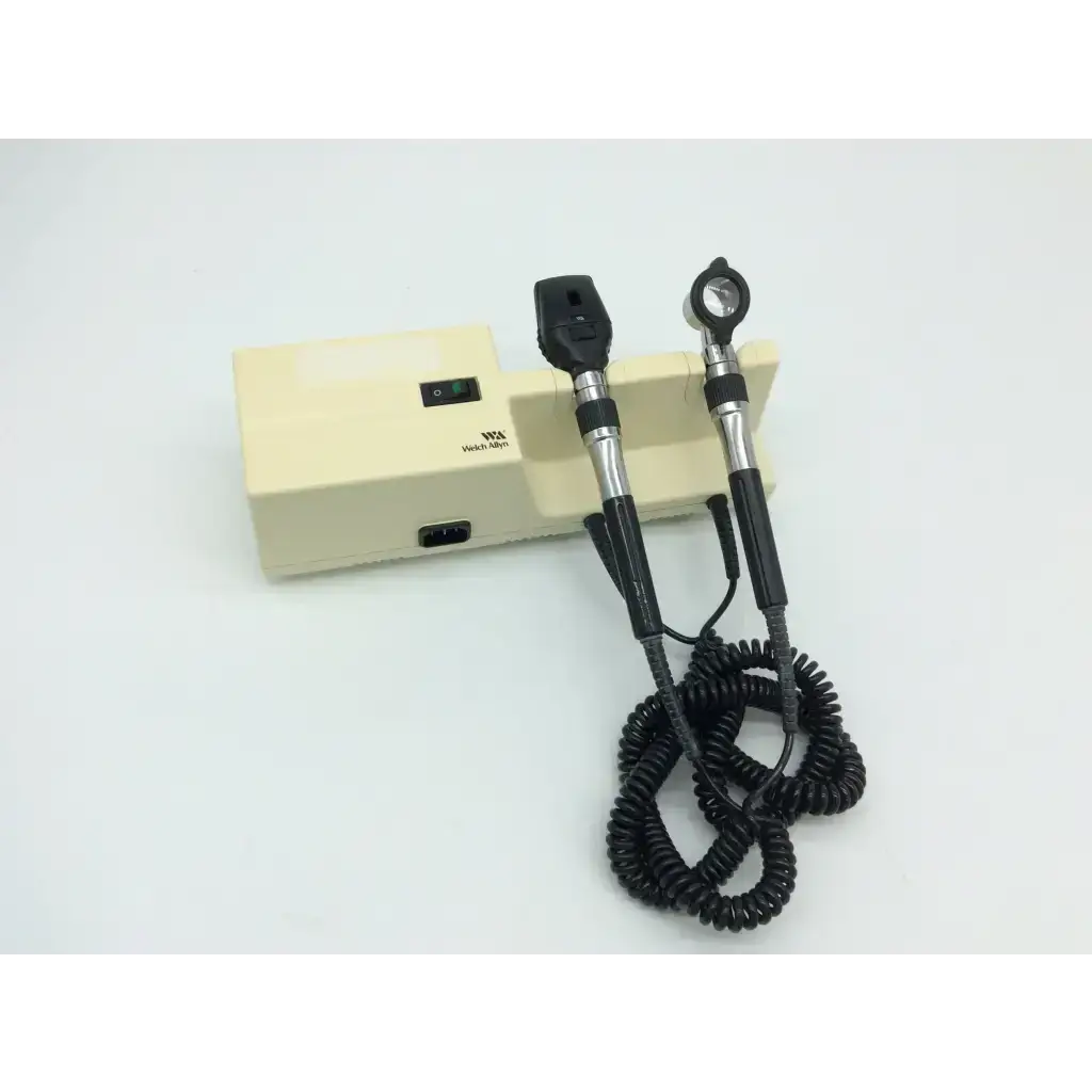 Welch Allyn 767 series wall transformer with black silver ophthalmoscope handles and coiled cable on beige base unit