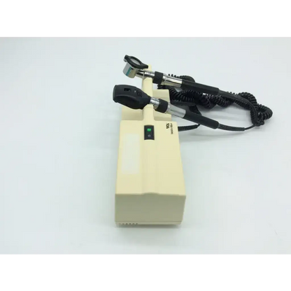 Cream-colored welch allyn 767 series wall transformer with black otoscope handles and coiled cords for medical use