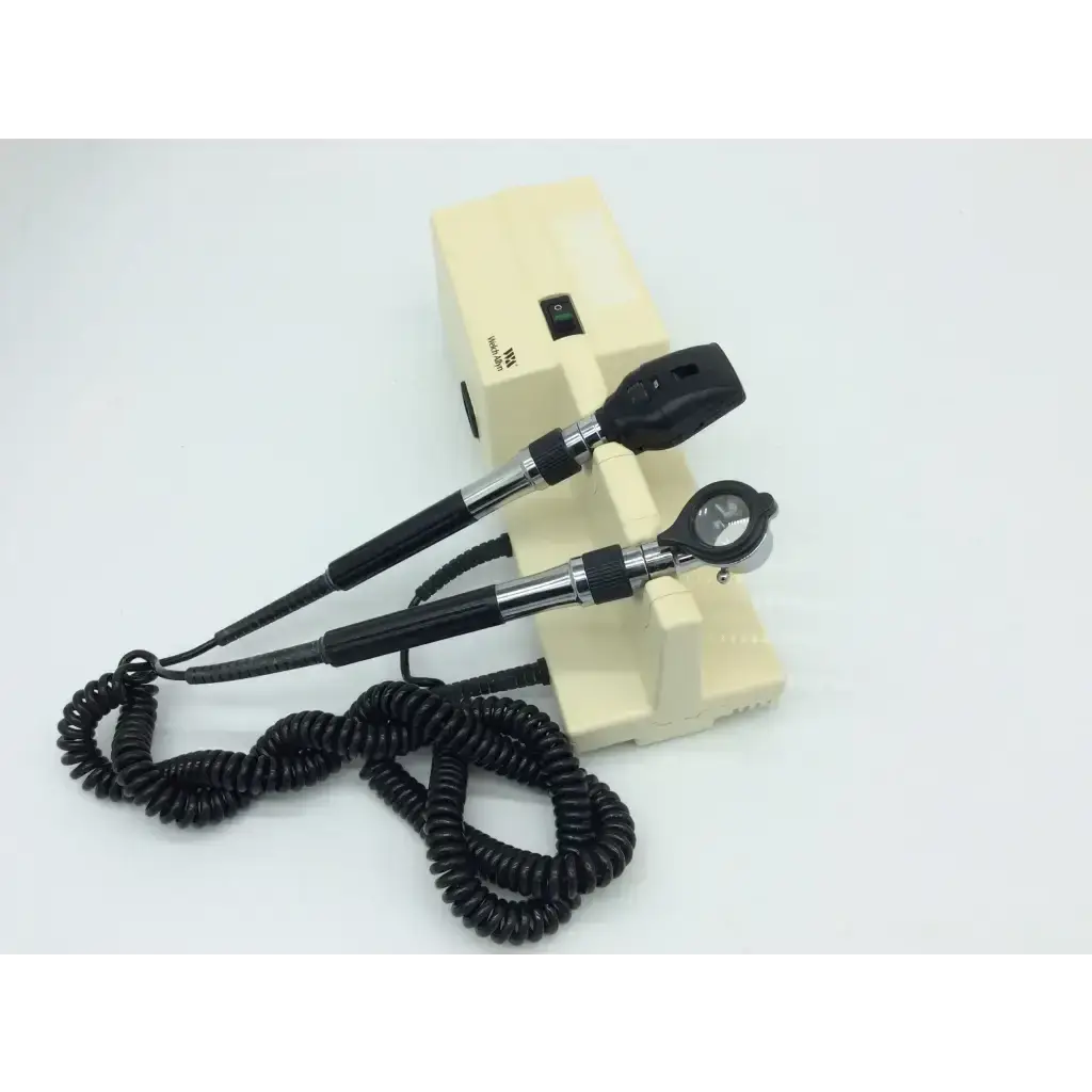 Black and silver ophthalmoscope with coiled cord on cream base part of welch allyn 767 series wall transformer set