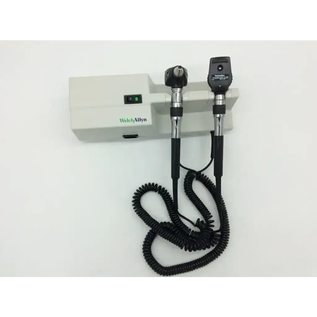 Black and silver welch allyn ophthalmoscope with coiled cord mounted on white welch allyn wall transformer 25020a unit