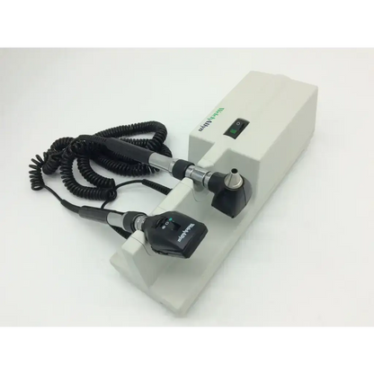 Beckman coulter otoscope with black and silver handle attached to white welch allyn 767 wall transformer 25020a base unit