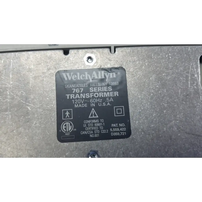 Black rectangular label on metallic surface identifies welch allyn 767 wall transformer for reuse medical devices