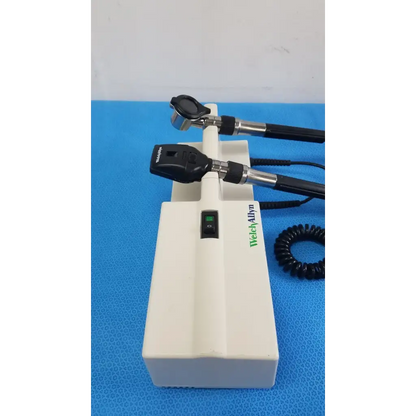 Welch Allyn white plastic wall transformer base with two black and silver reuse medical otoscope heads