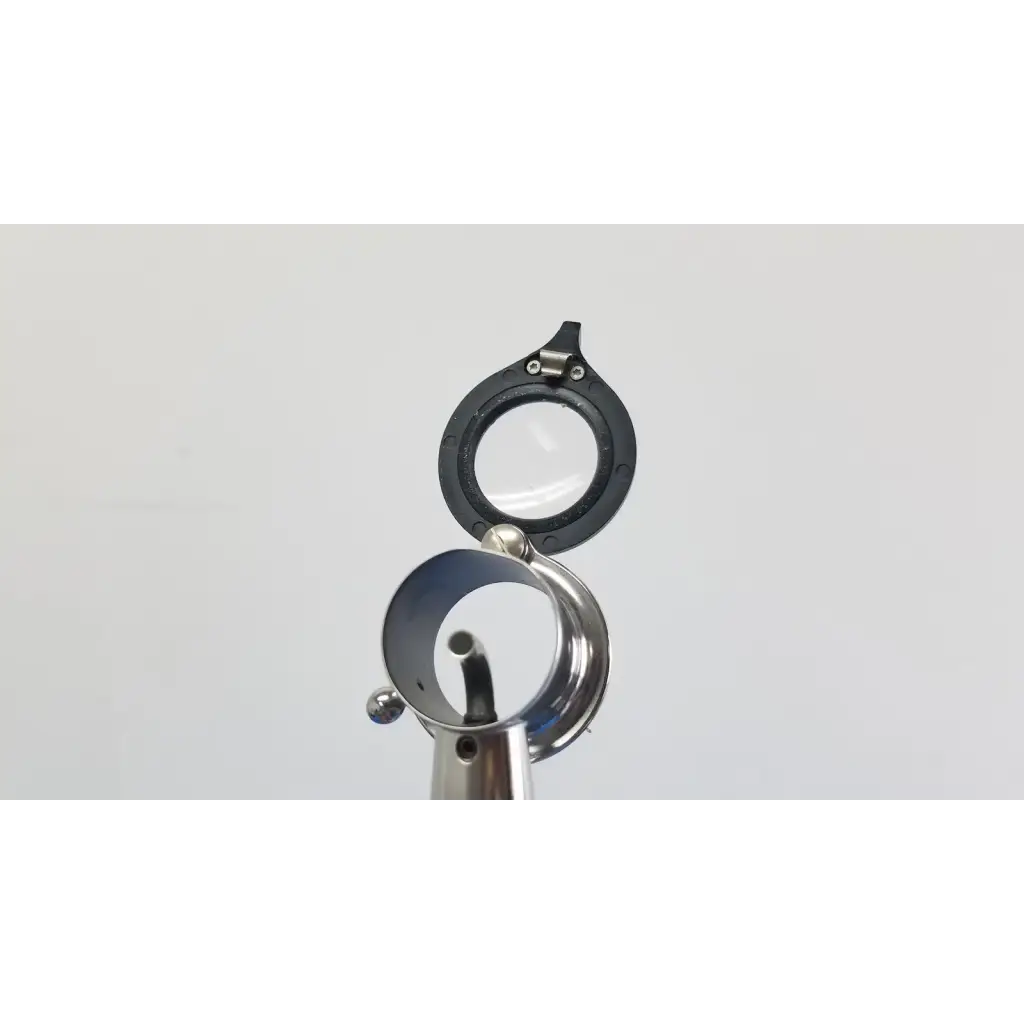 Black-rimmed magnifying glass with metallic reflective base and hinge in welch allyn wall transformer with coaxial ophthalmoscope