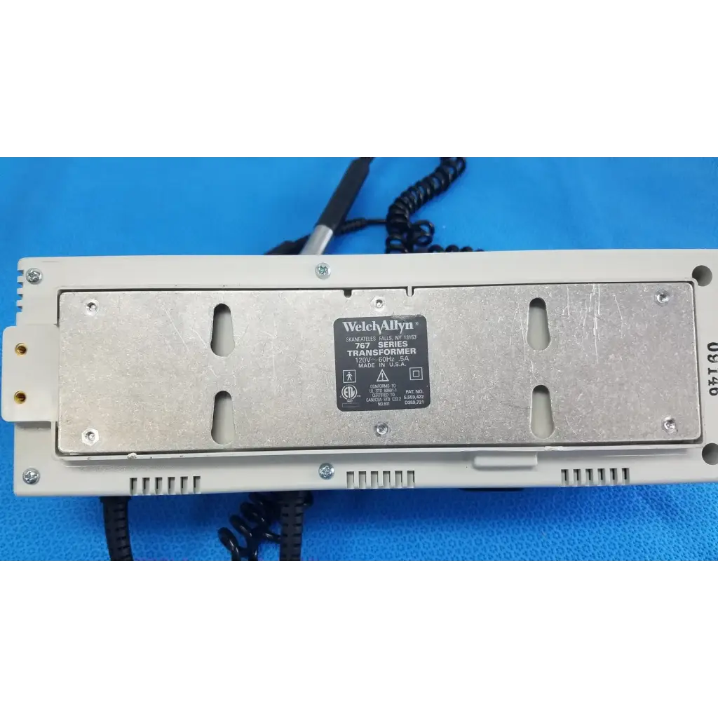 White plastic housing with silver metal plate showing welch allyn 767 series wall transformer label for reuse medical use