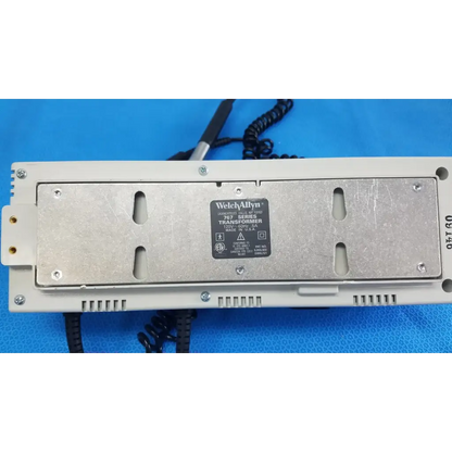 White plastic housing with silver metal plate showing welch allyn 767 series wall transformer label for reuse medical use