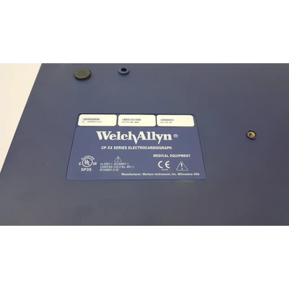 Dark blue welch allyn cp10 ekg machine with certification label and manufacturer info on the back side of the device