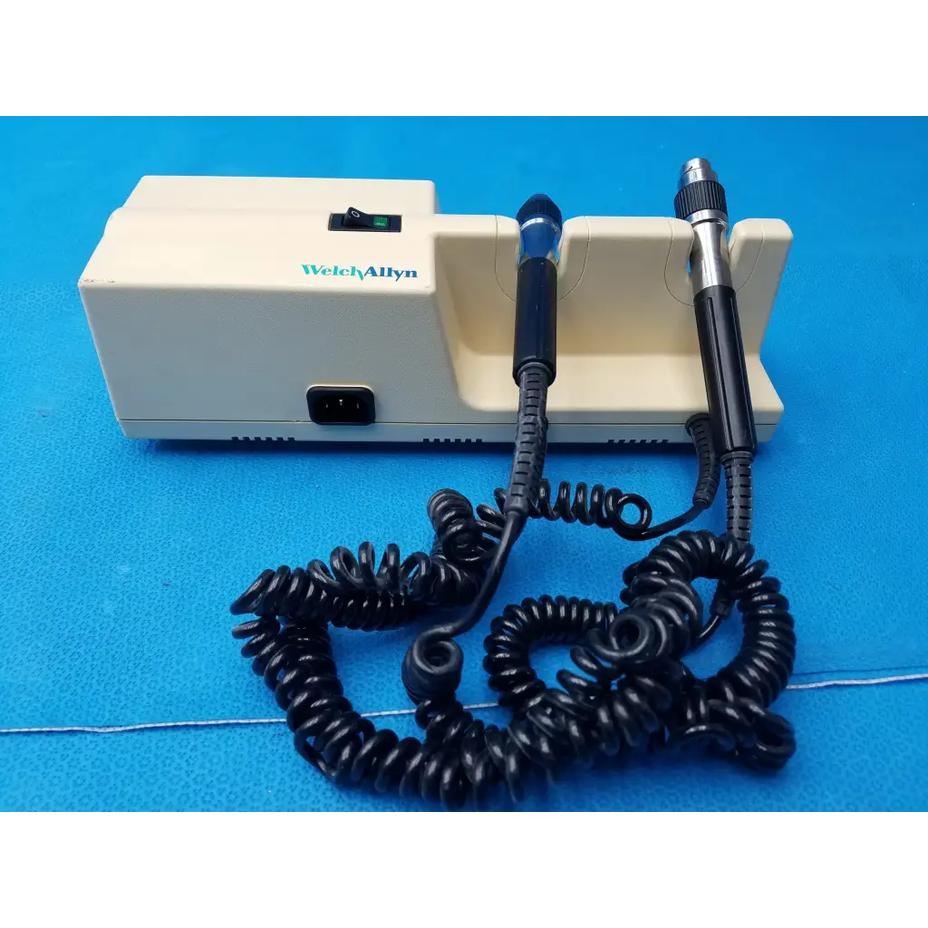 Cream-colored welch allyn diagnostic wall transformer with two black-handled probes and coiled black cords no heads