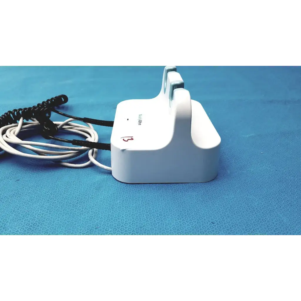 White plastic welch allyn wall transformer charging dock with coiled black and white reuse medical cables