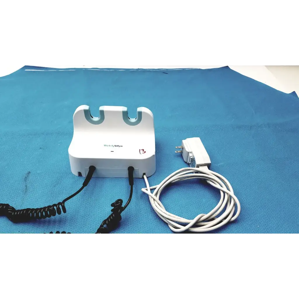 White plastic welch allyn gs 777 wall transformer with blue curved slots and black coiled cords for ophthalmoscope otoscope