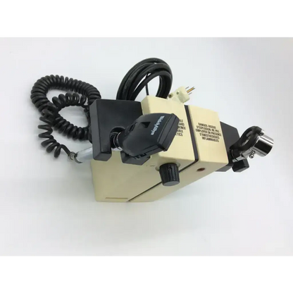 Beckman coulter microscope with beige body black and silver parts and coiled cord shown with welch allyn wall transformer diagnostic set ophthalmoscope