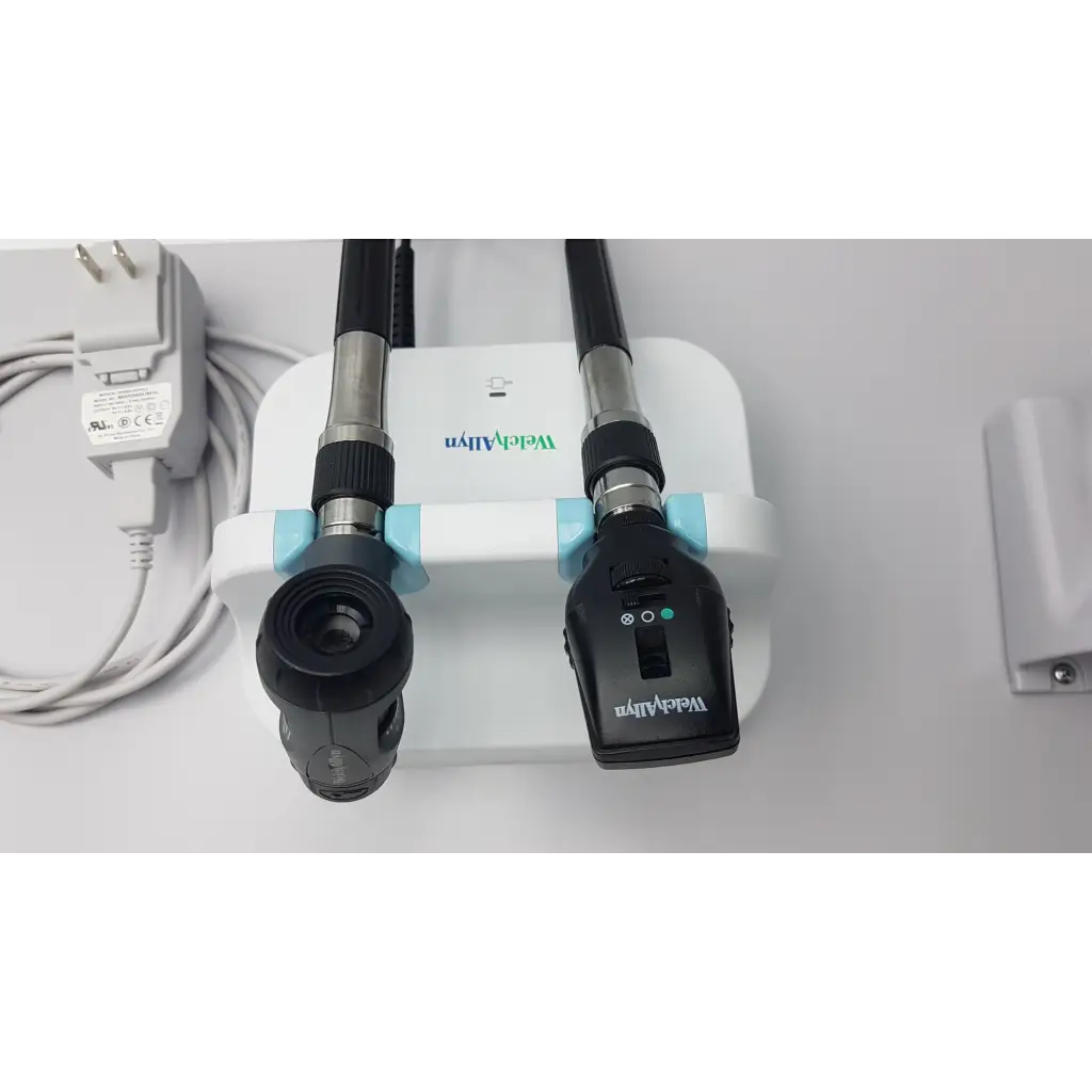 Black and silver welch allyn diagnostic set with wall transformer otoscope ophthalmoscope mounted on white base