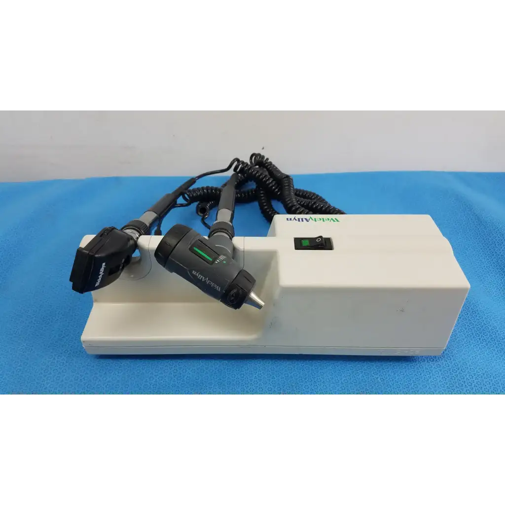 White rectangular welch allyn wall transformer with two black handheld otoscope and ophthalmoscope heads and coiled cords