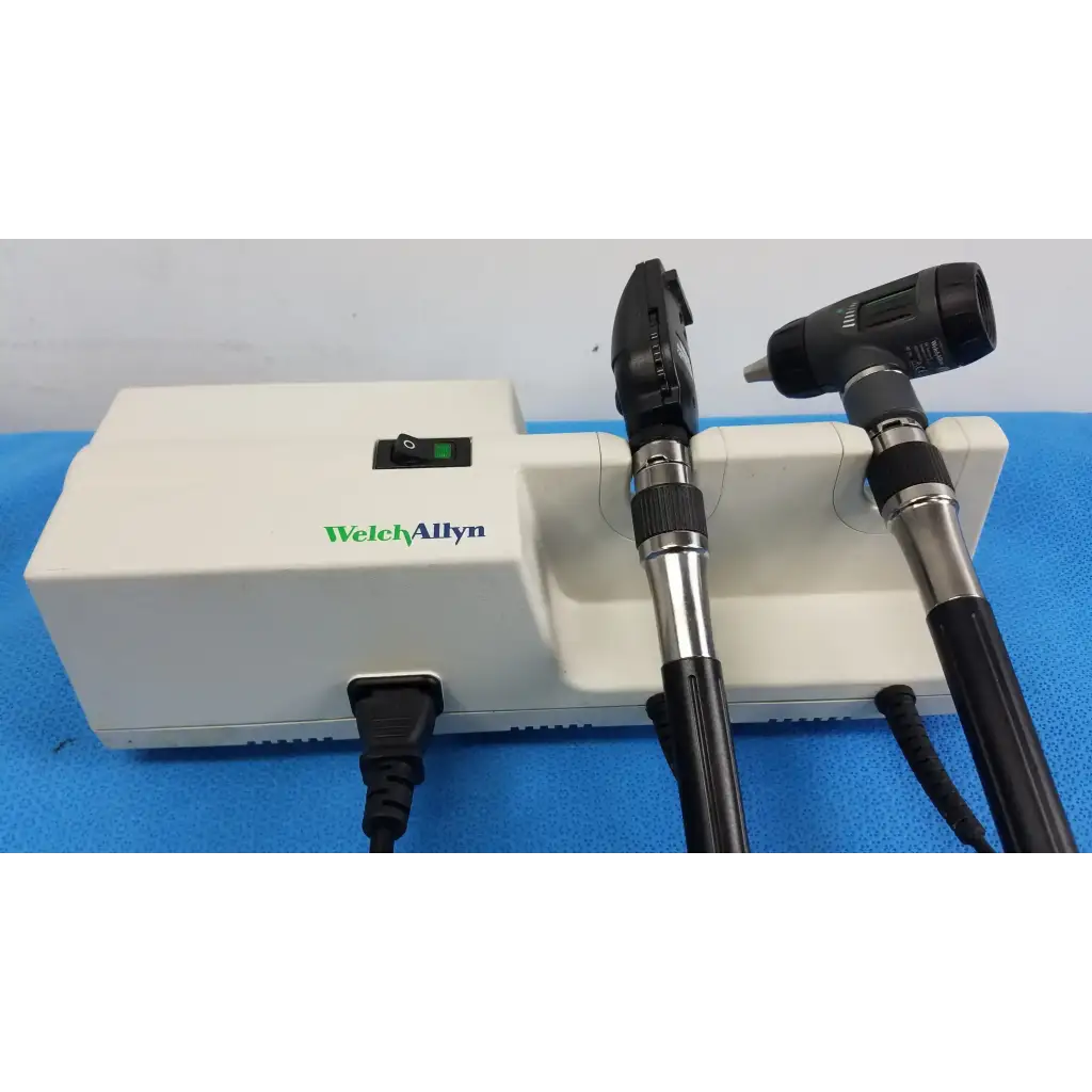 Welch allyn wall transformer with black and silver Welch allyn otoscope resting on a white base unit