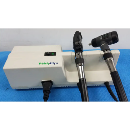 Welch allyn wall transformer with black and silver Welch allyn otoscope resting on a white base unit