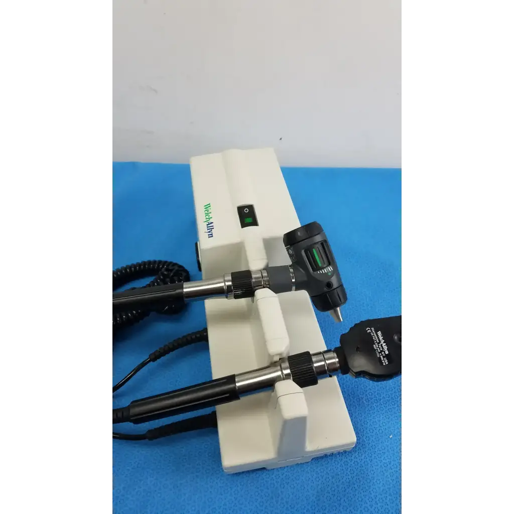 White plastic welch allyn wall transformer stand holding two black and silver otoscope and ophthalmoscope heads