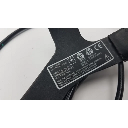 Black plastic welchallyn headlight 49540 with fibrotic cable black and white label showing manufacturer details