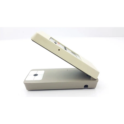 Beige and gray two-tone portable x-rite rmi densitometer ac5-377 with hinged lid and integrated camera lens on base