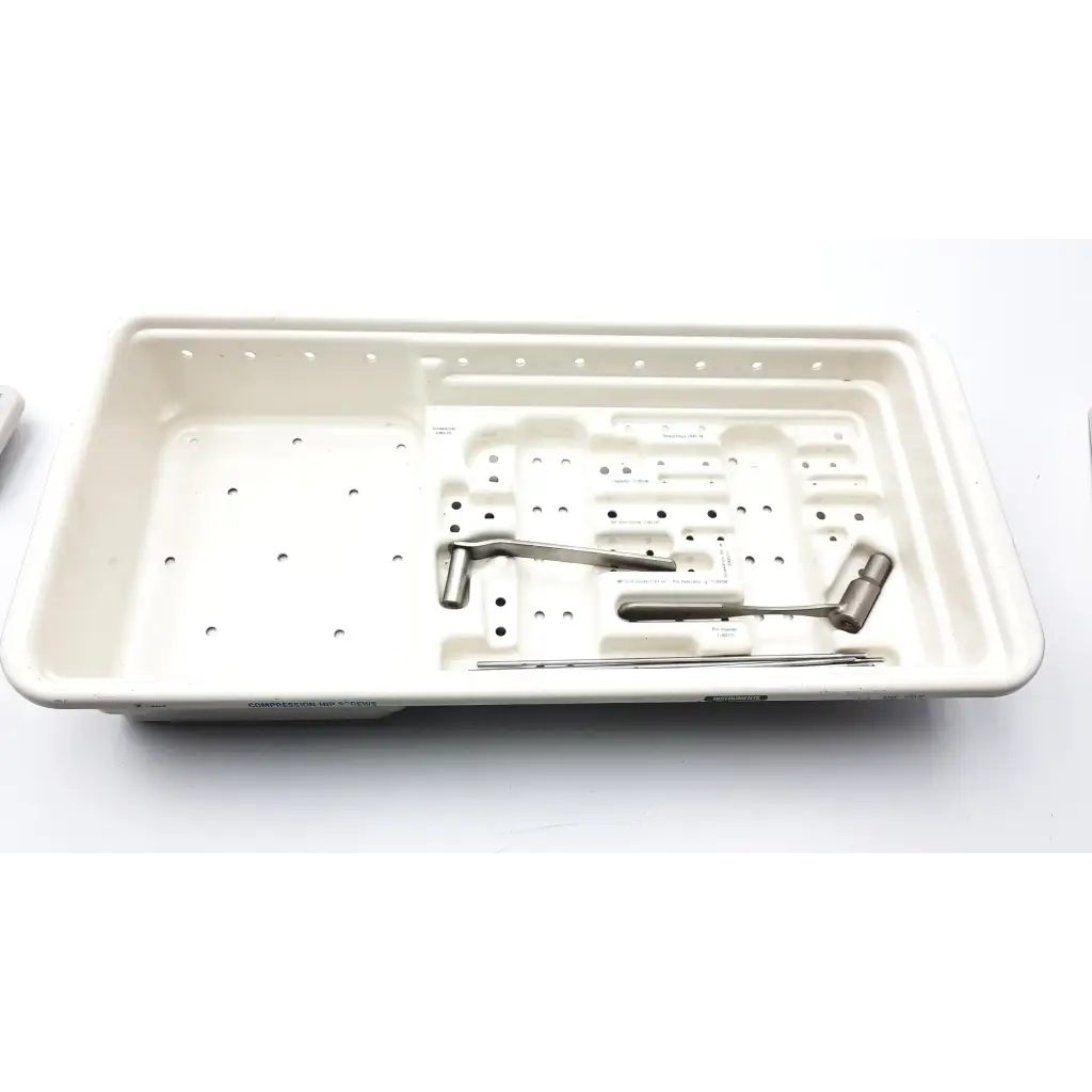 White plastic surgical instrument tray with metallic tools in zimmer compression hip screws kit for orthopedic use