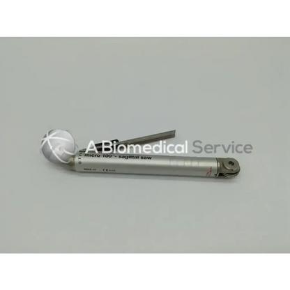 Silver-colored micro 100 sagittal saw with white crosshatch handle and metallic blade in zimmer linvatec hall surgairtome two set